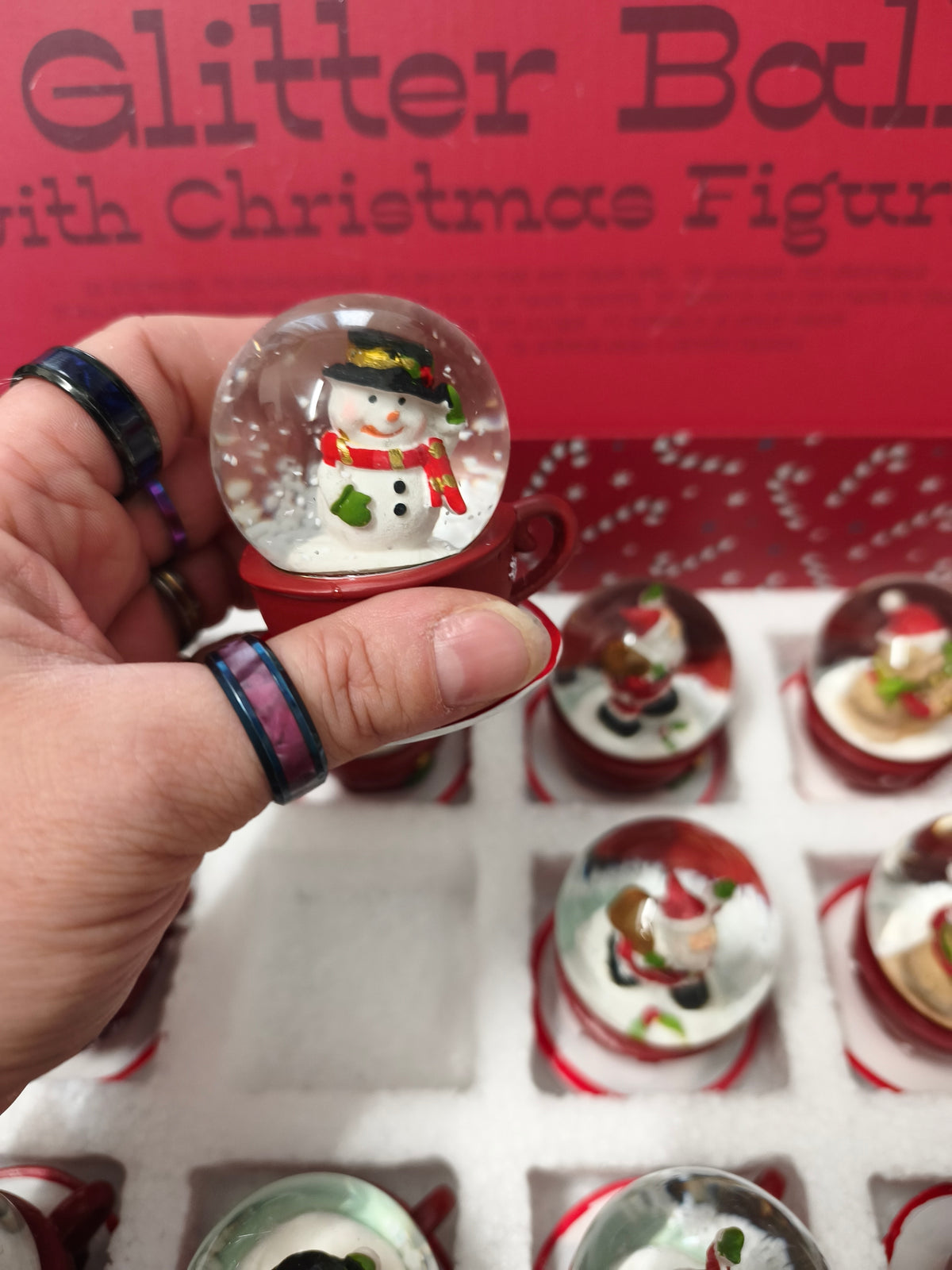 Une Boule à neige en polyrésine avec figurine de Noël sur tasse à café rouge