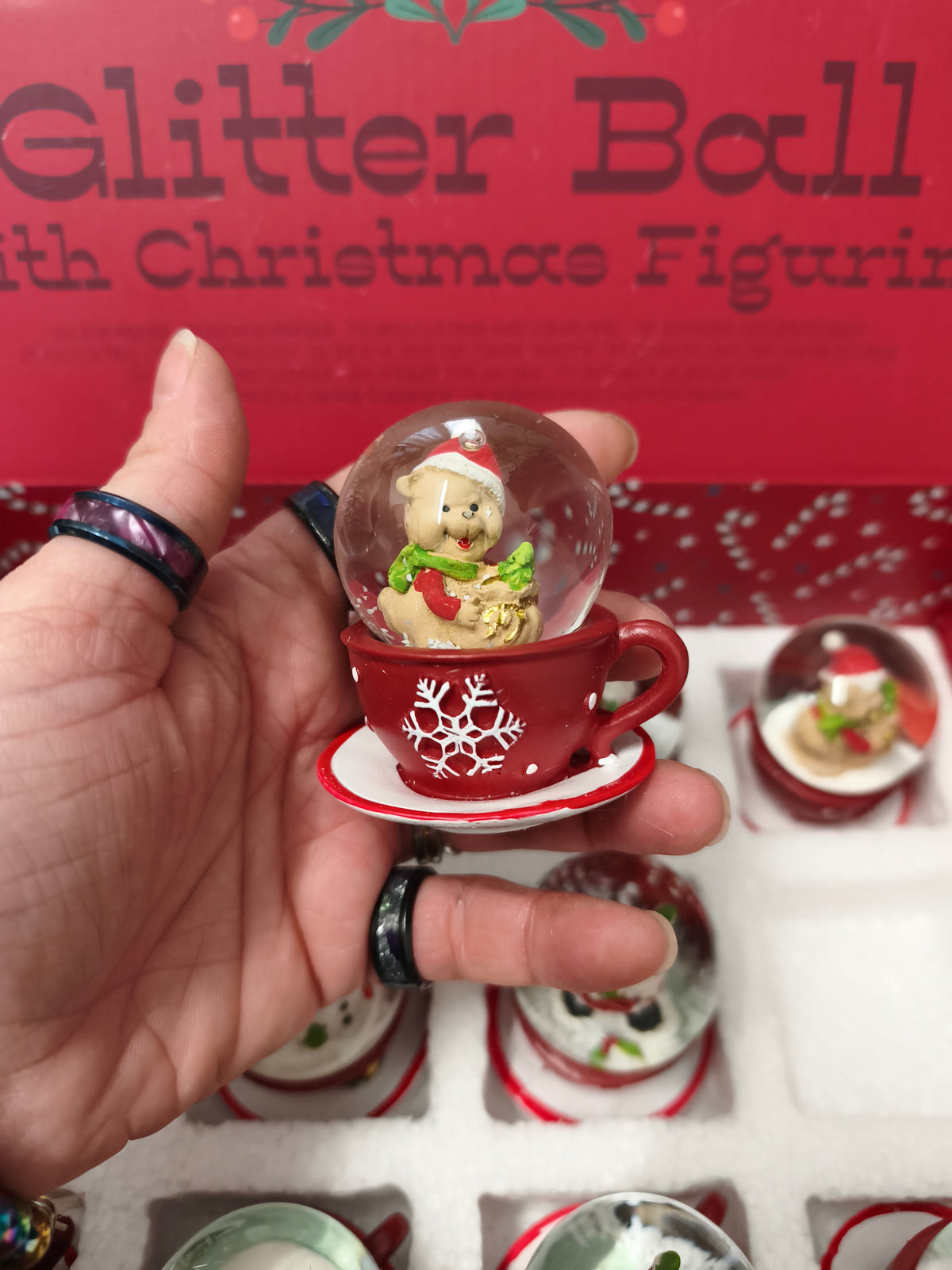 Une Boule à neige en polyrésine avec figurine de Noël sur tasse à café rouge