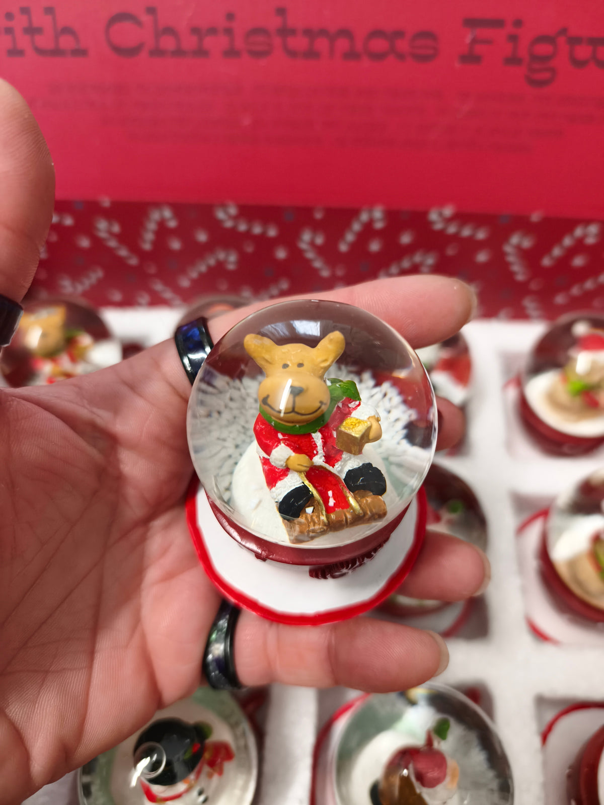 Une Boule à neige en polyrésine avec figurine de Noël sur tasse à café rouge